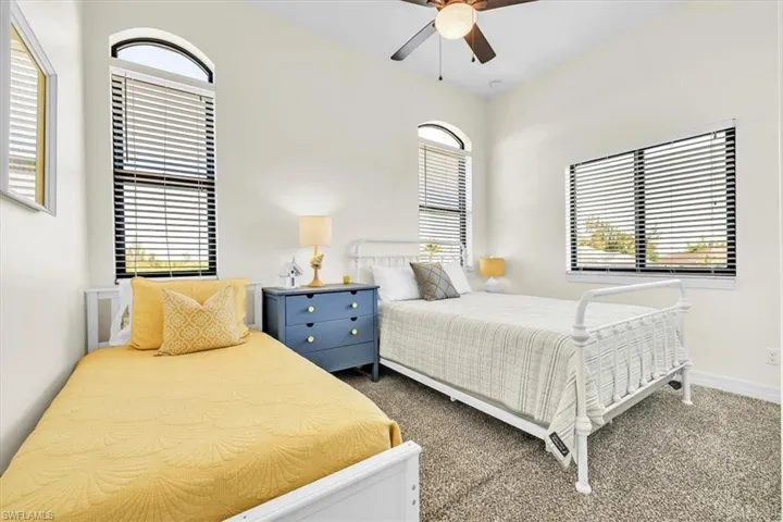 Carpeted room featuring a vaulted ceiling and a ceiling fan with light fixture