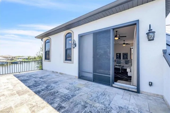 Spacious outdoor patio featuring tiled flooring and black metal railing