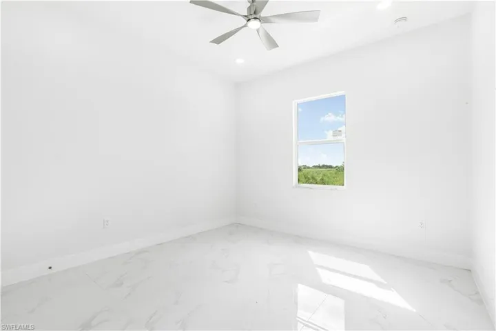 Tiled spare room with ceiling fan