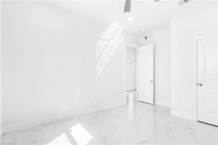 Unfurnished bedroom with ceiling fan and light tile patterned flooring