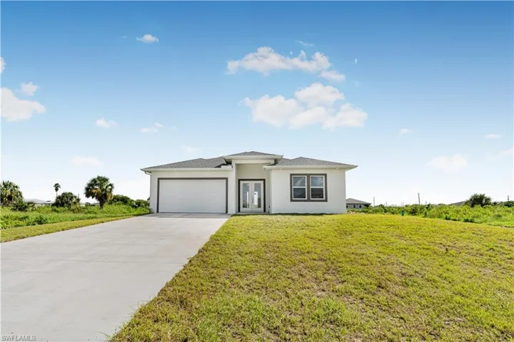 View of front of house featuring a garage and a front lawn