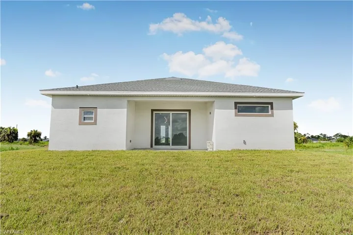 Rear view of house with a lawn