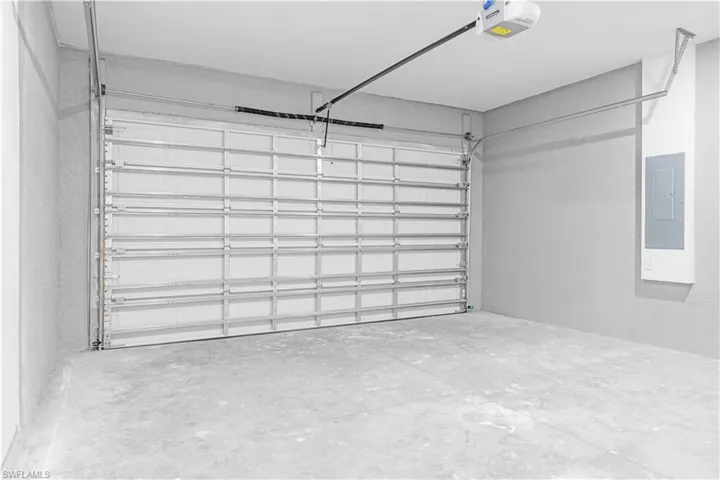 Garage featuring electric panel and a garage door opener