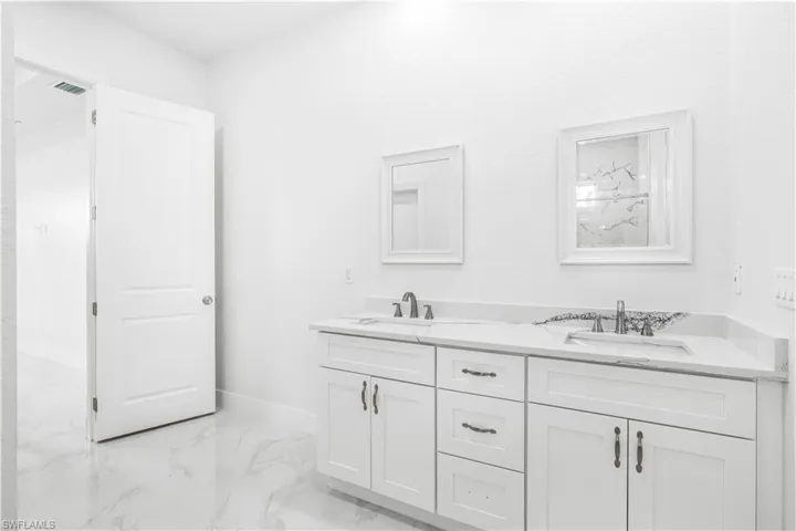 Bathroom with dual vanity and tile patterned flooring