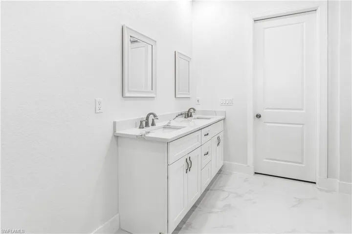 Bathroom featuring double sink vanity and tile patterned flooring