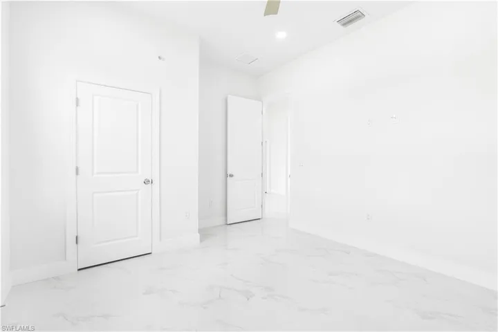 Unfurnished bedroom with light tile patterned flooring and ceiling fan