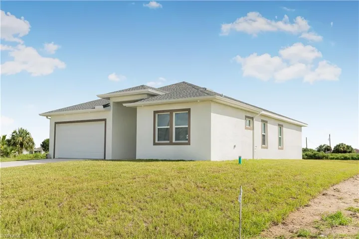 View of front of home featuring a front lawn and a garage