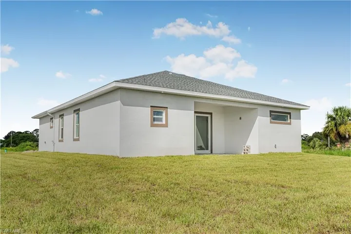 Rear view of house featuring a lawn