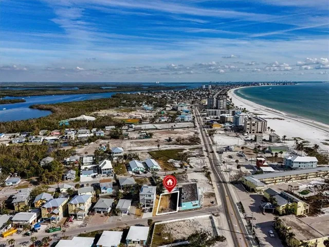 Birds eye view of property with a view of the beach and a water view
