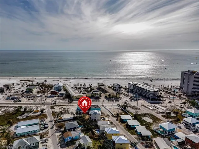 Birds eye view of property with a water view and a view of the beach