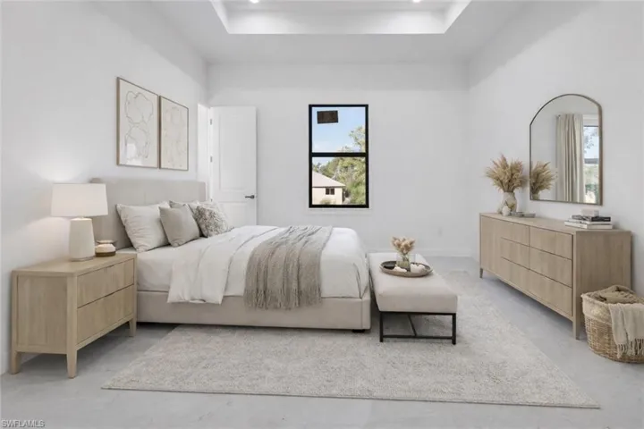 Bedroom featuring a raised ceiling and finished concrete flooring