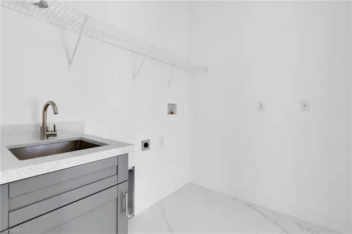 Laundry area with electric dryer hookup, light marble finish flooring, and hookup for a washing machine