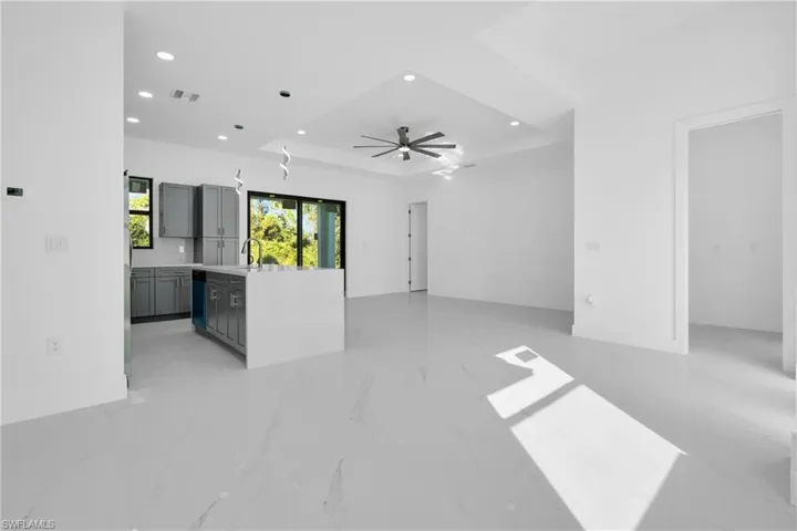Unfurnished living room featuring light marble finish flooring, recessed lighting, and a ceiling fan