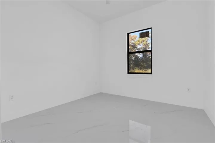 Unfurnished room with light marble finish floors
