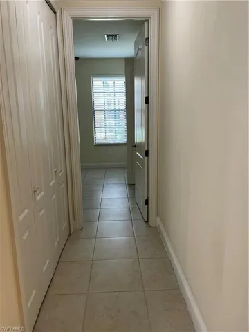 Hallway featuring baseboards and light tile patterned flooring