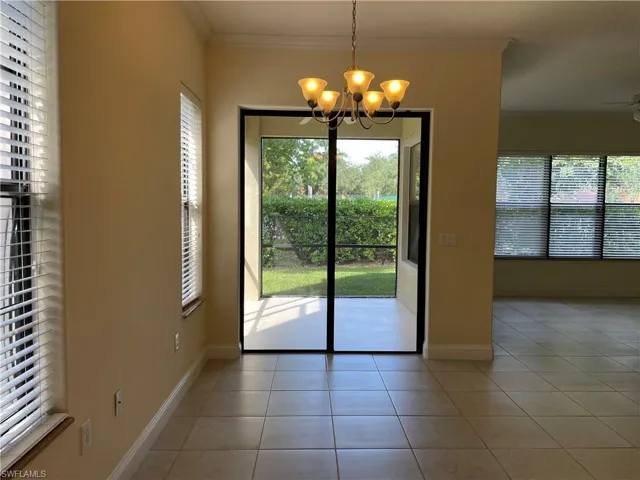 Unfurnished dining area featuring light tile patterned flooring, ornamental molding, hanging lights, and ceiling fan