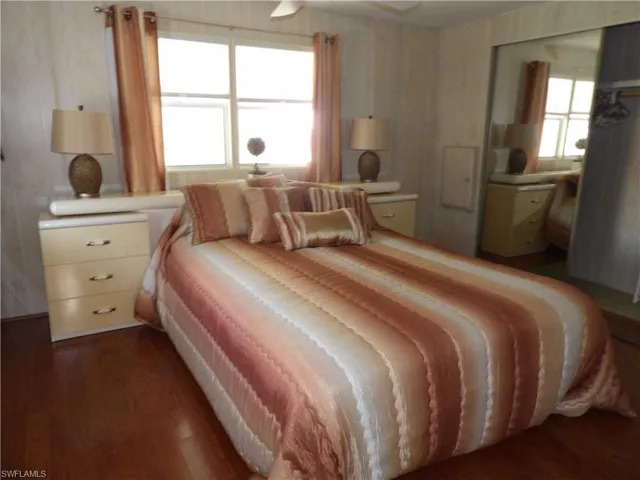 Bedroom featuring dark wood-style floors, a closet, and ceiling fan