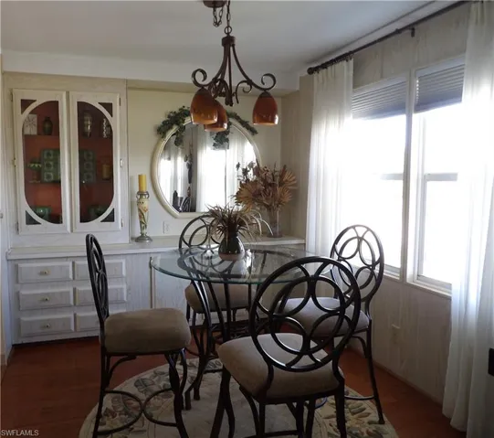 Dining room with plenty of natural light and dark wood-style floors
