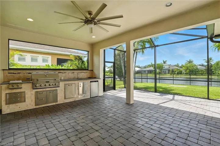 Unfurnished sunroom featuring area for grilling, a water view, and ceiling fan