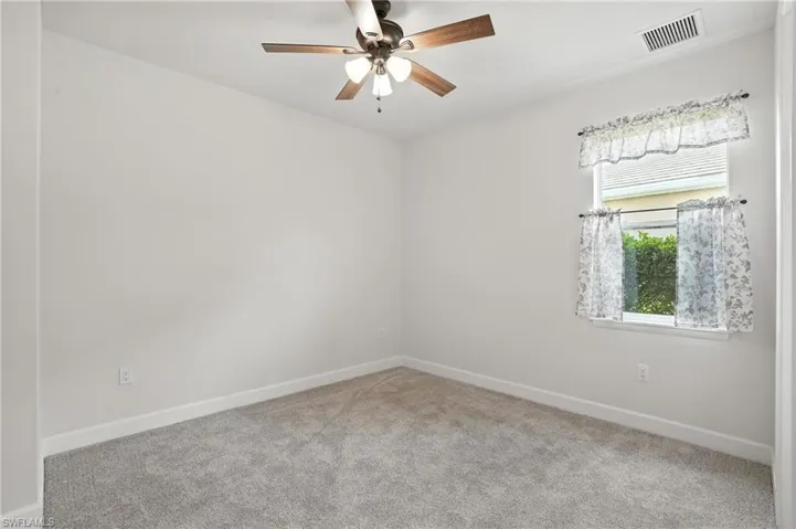 Unfurnished room featuring carpet floors and ceiling fan