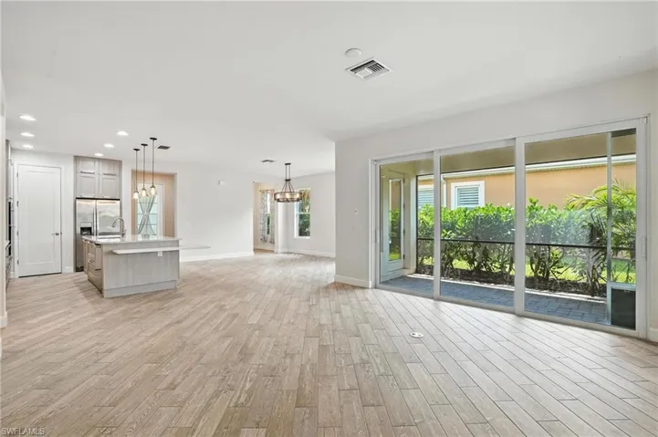 Unfurnished living room featuring a chandelier, light wood-style floors, and recessed lighting