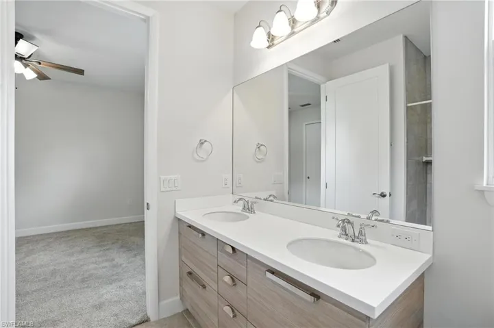 Full bathroom with double vanity and ceiling fan