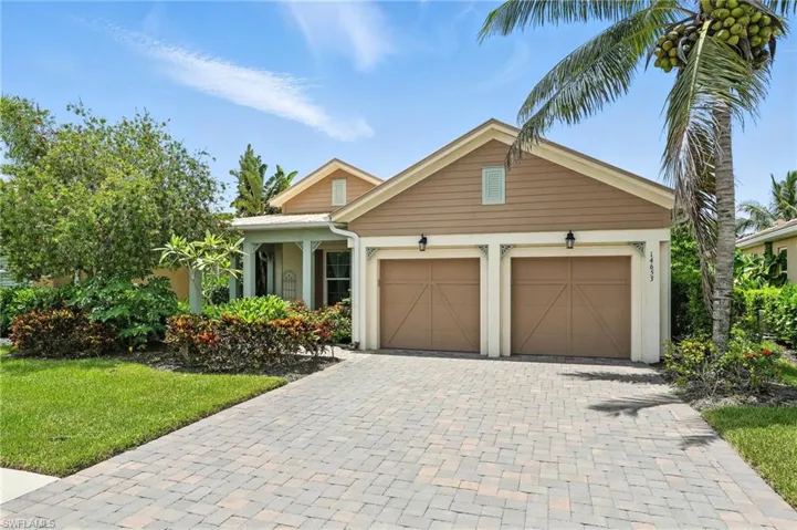 View of front facade featuring driveway, a garage, and a front lawn