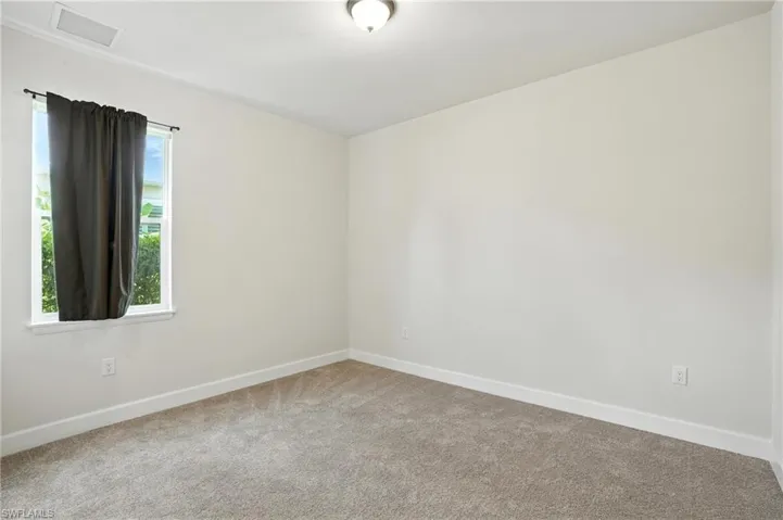 Carpeted empty room featuring baseboards