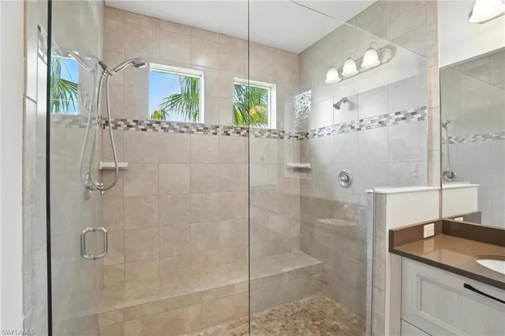Bathroom with tiled shower and vanity