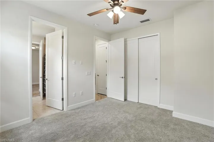 Unfurnished bedroom with carpet floors, a closet, and a ceiling fan