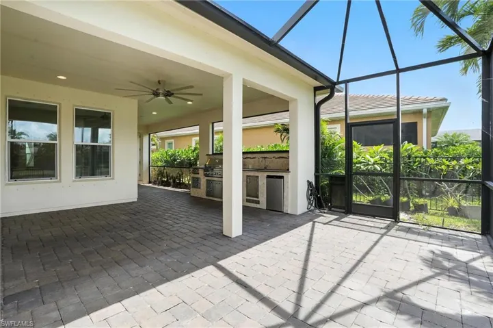 Unfurnished sunroom with exterior kitchen and ceiling fan