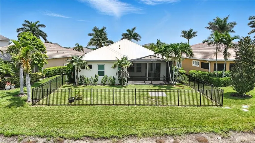 Back of property with a fenced backyard and stucco siding
