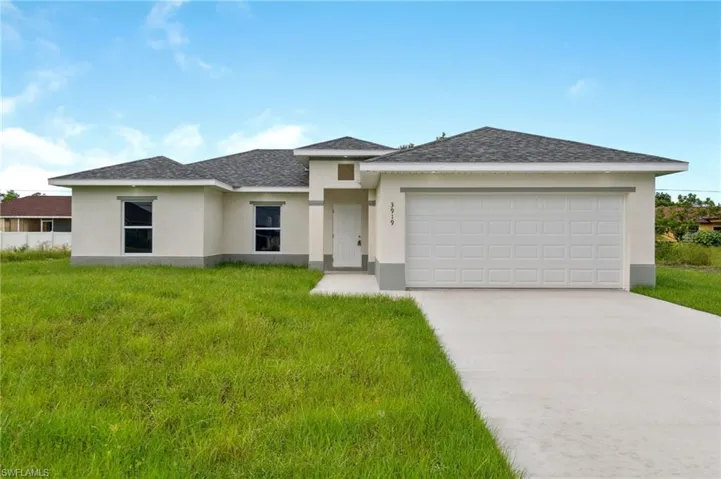 View of front of property featuring a garage and a front lawn