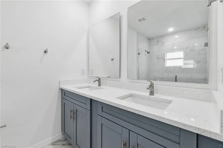 Bathroom with a shower with shower door and vanity