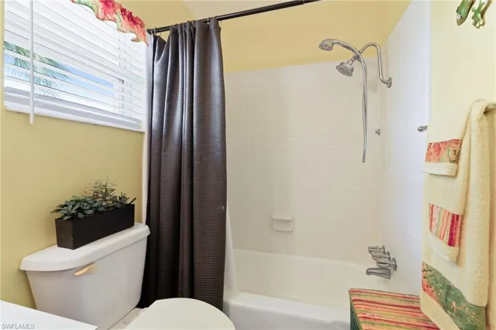 Bathroom featuring shower / tub combo with curtain and toilet