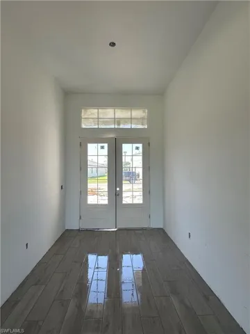 Empty room featuring dark hardwood / wood-style floors and french doors