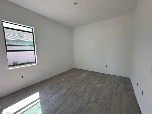 Spare room featuring wood-type flooring