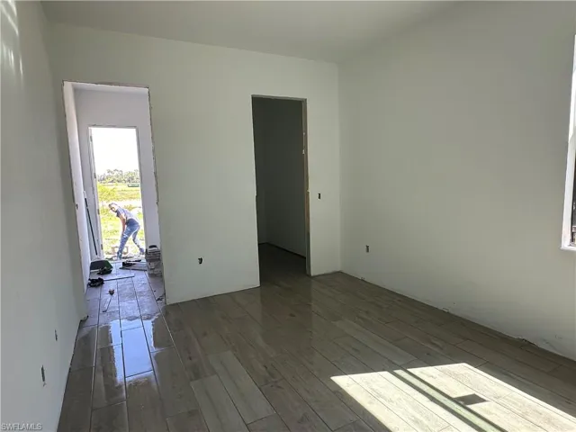 Empty room featuring dark wood-type flooring