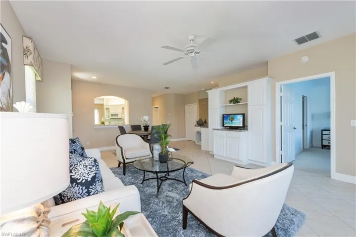 Living room featuring ceiling fan and light tile floors