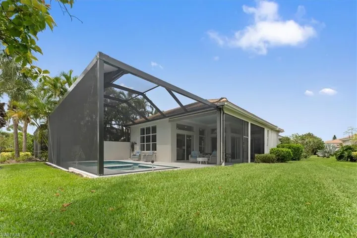 Back of property featuring a lawn, a lanai, stucco siding, an outdoor pool, and a patio area