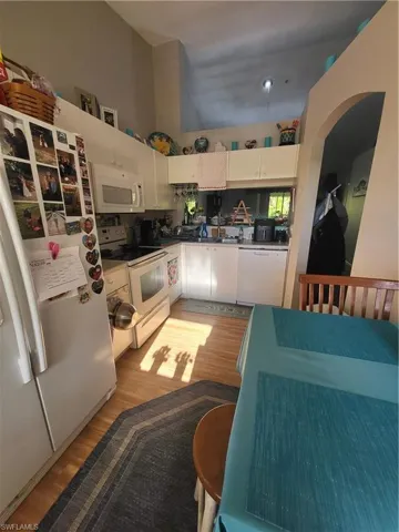Kitchen featuring refrigerator, stove, light wood-type flooring, and dishwashing machine