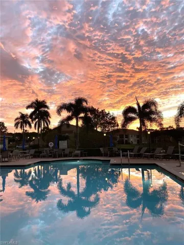 Pool at dusk with a community pool and a patio area
