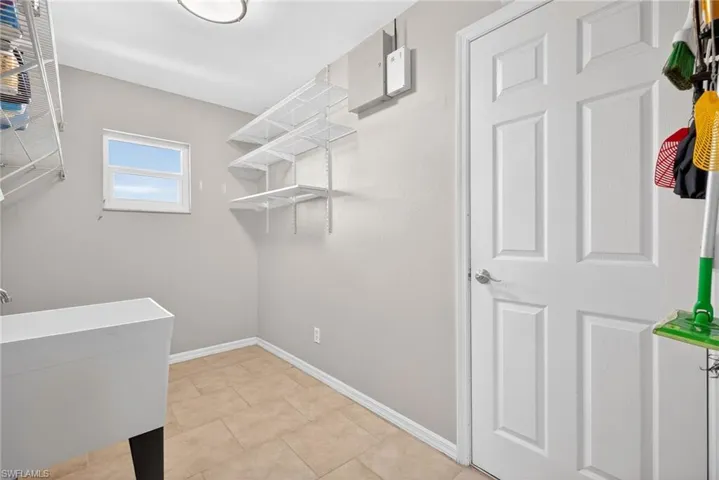 Laundry room with a sink and baseboards