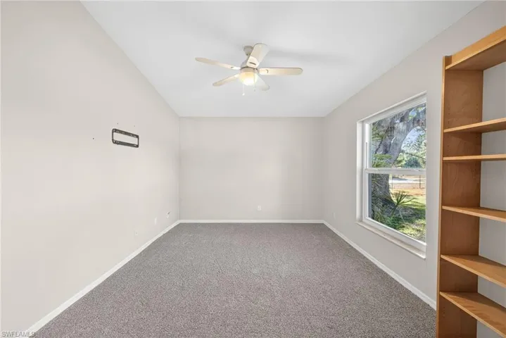 Carpeted empty room with baseboards and ceiling fan