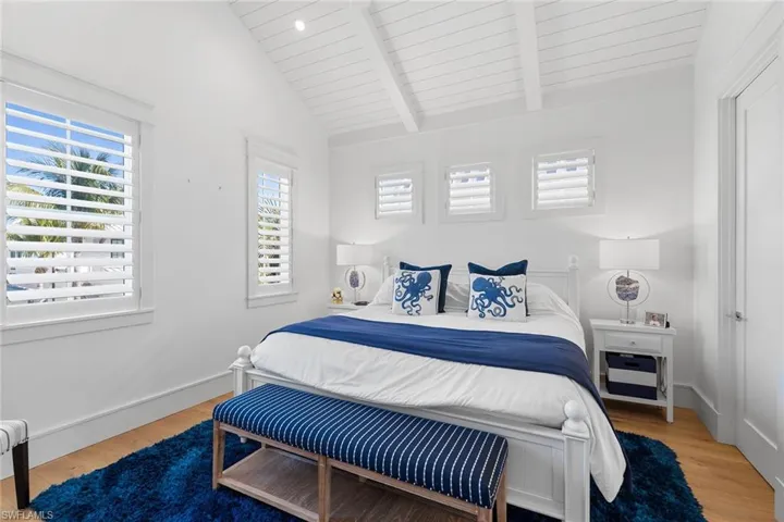 Bedroom featuring light wood-style floors, vaulted ceiling with beams, and wood ceiling