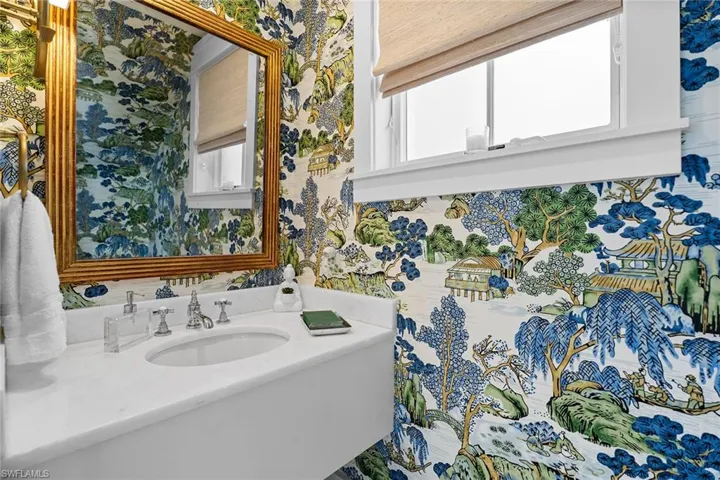 Bathroom with vanity and wallpapered walls