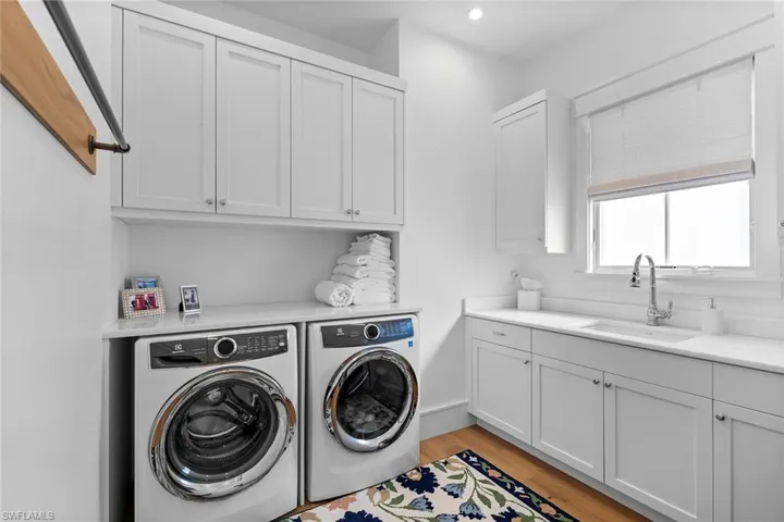 Laundry room with light wood-style flooring, independent washer and dryer, and cabinet space
