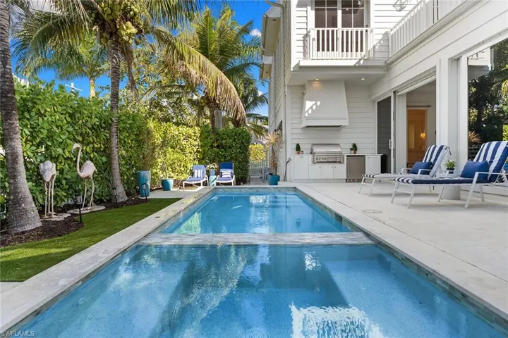 Combined pool / hot tub with area for grilling, a balcony, and a patio area