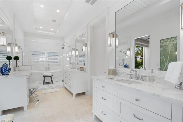 Bathroom with two vanities, a freestanding bath, recessed lighting, a stall shower, and wooden ceiling