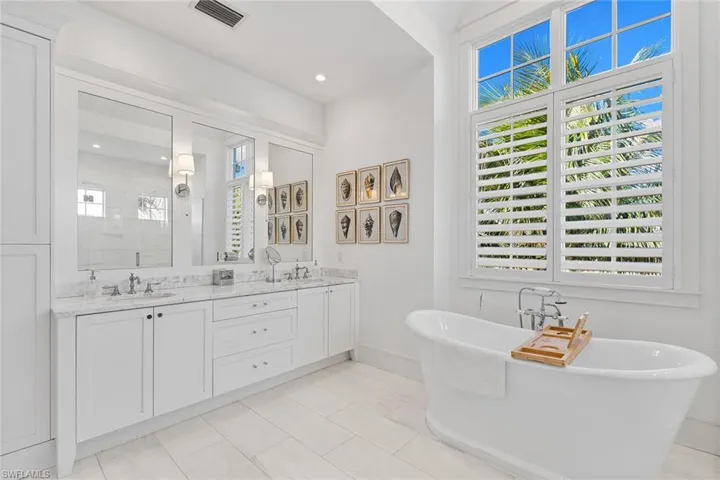 Full bathroom featuring double vanity, a soaking tub, and a shower stall